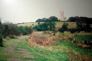 View of the abandoned track bed in 1984, the grass-covered line curving around to the right with the cathedral dominating the hill above.